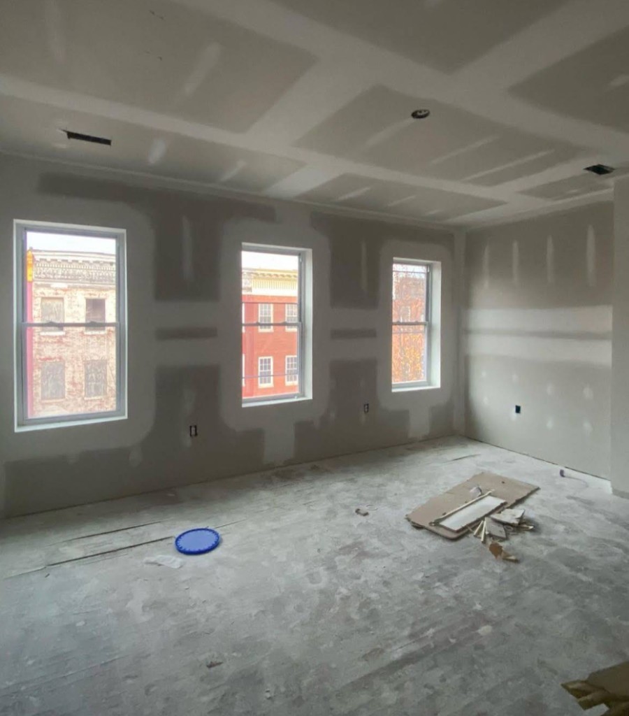 Interior room with drywall hung and finished along the walls and ceiling.