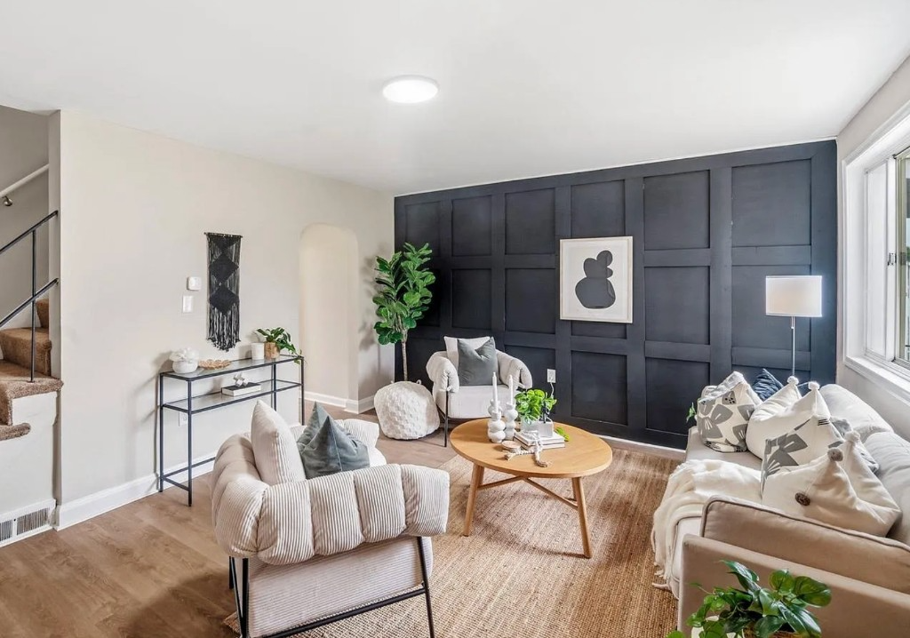 Living room with a dark board-and-batten accent wall and neutral furnishings.